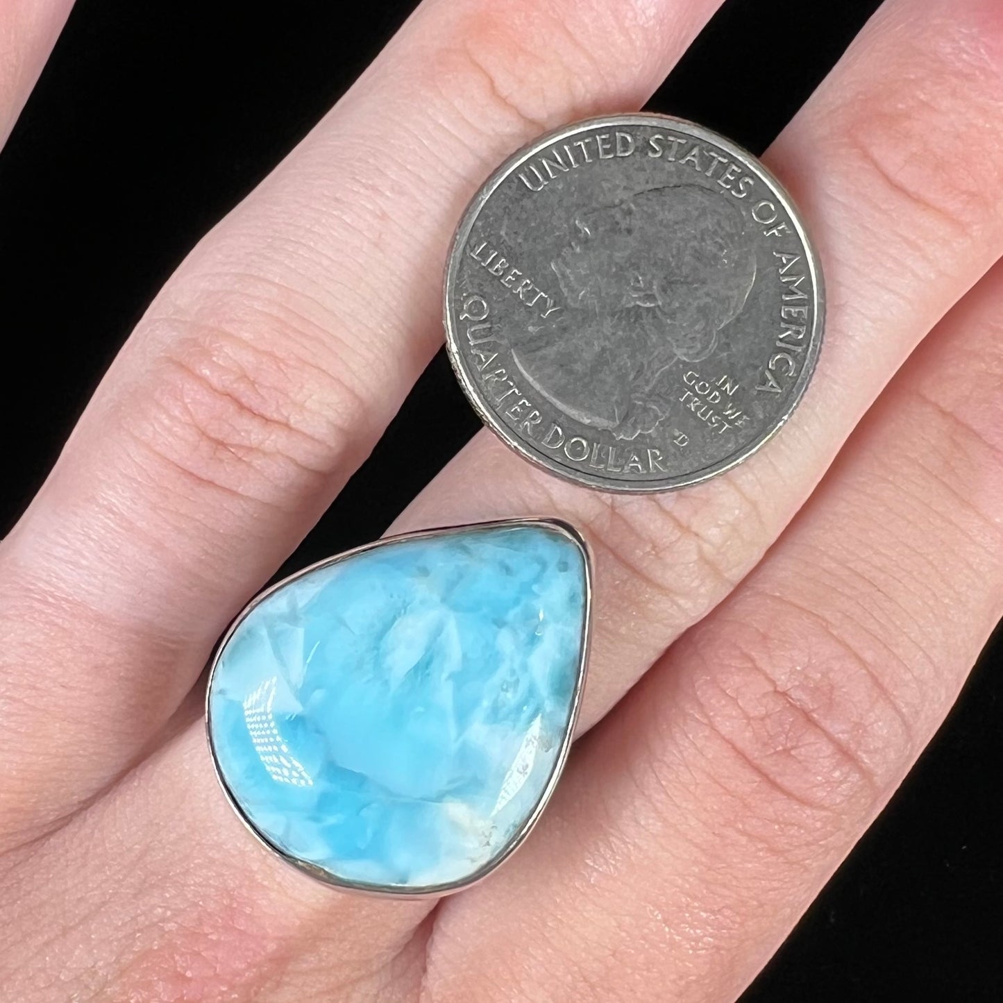 A ladies' large, pear shaped larimar solitaire ring in sterling silver.  The larimar stone measures an inch long.