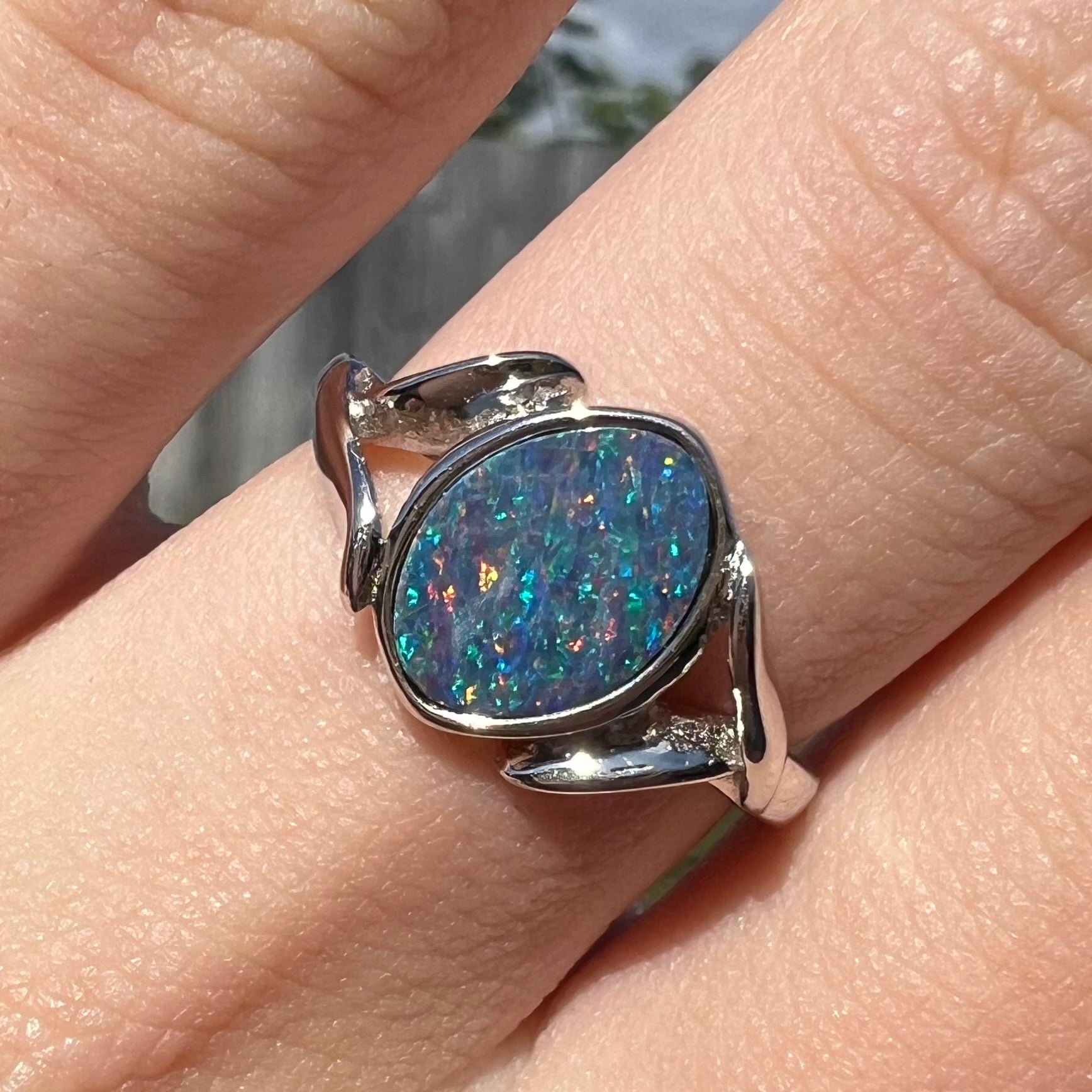 A silver leaf-style ring mounted with a multicolor black opal doublet.