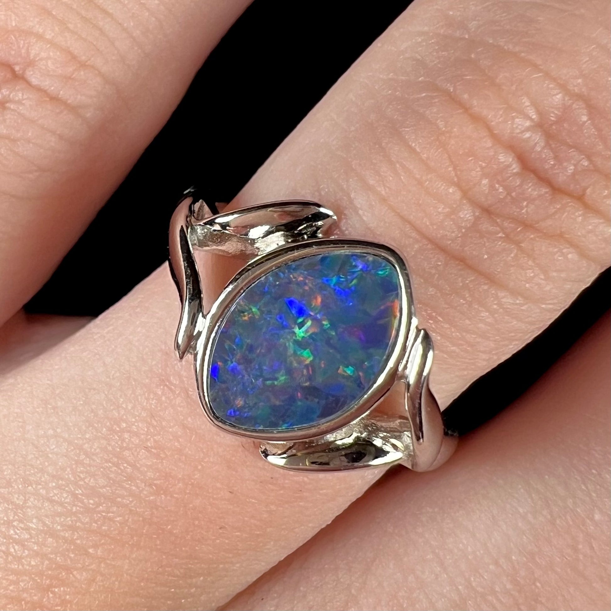 A sterling silver ring mounted with a marquise cut black opal doublet.  The opal has red fire.