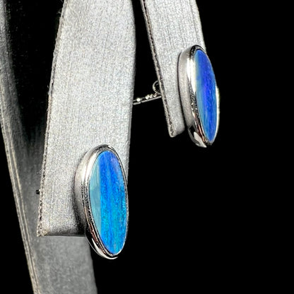 A pair of sterling silver opal doublet stud earrings.  The opals have a vivid blue color.