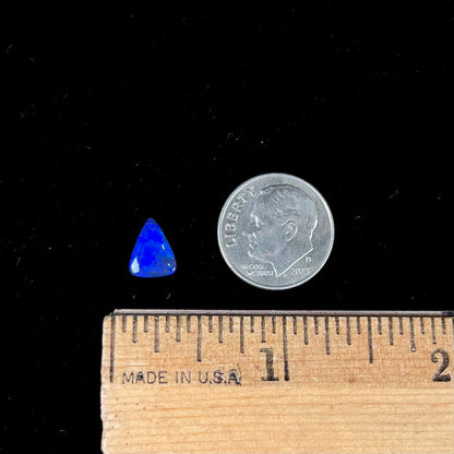 A loose, triangular cut black semi-crystal stone.