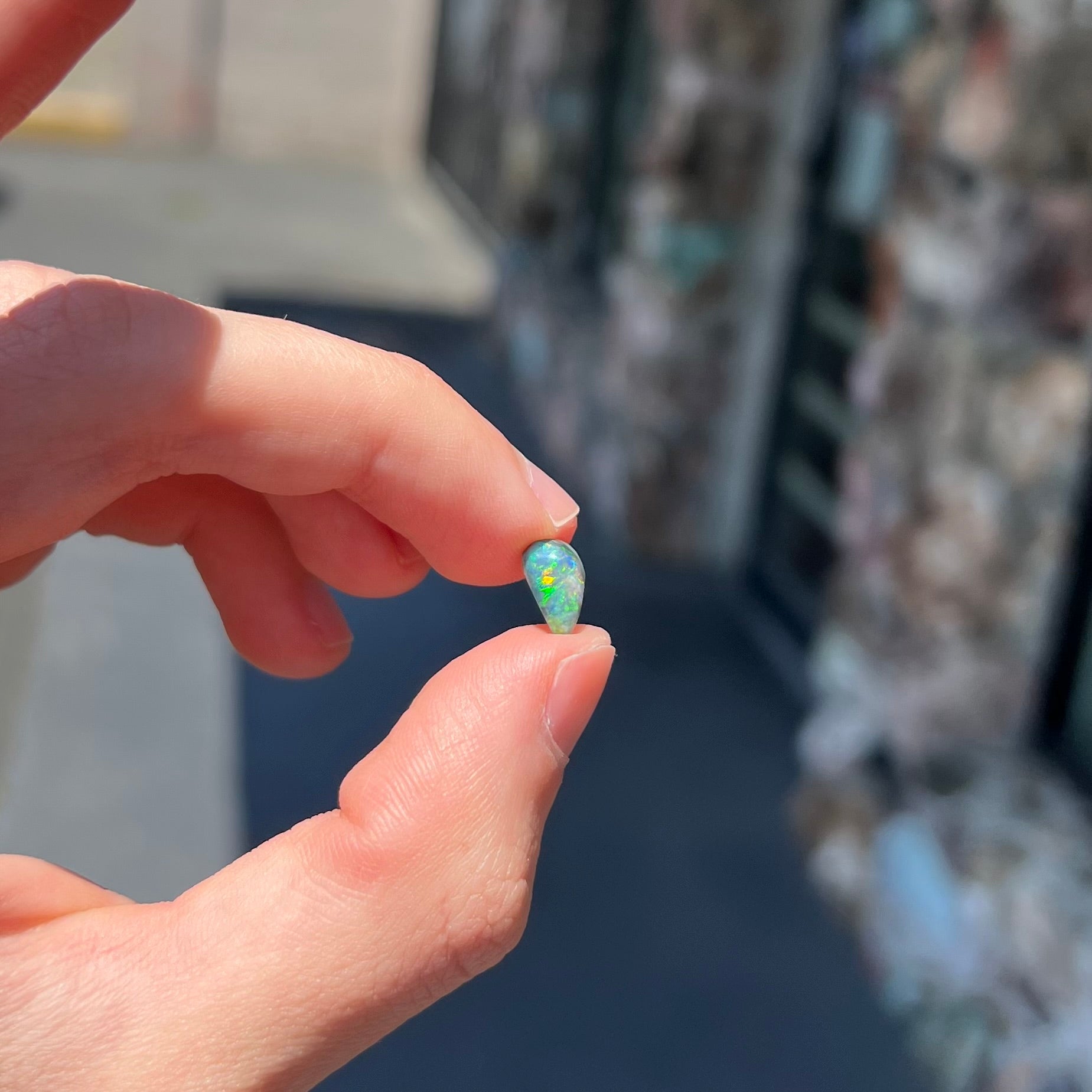 A black opal gemstone from Lightning Ridge, Australia.  The opal is a freeform cut.