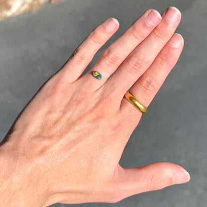 A loose, barrel shaped black opal stone from Lightning Ridge, Australia.