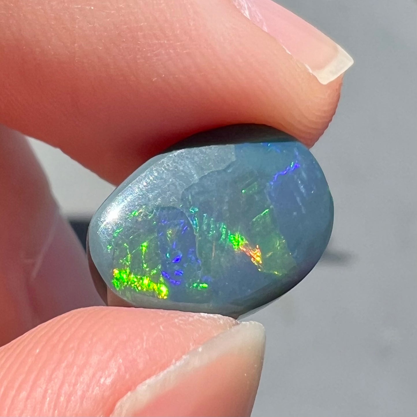 A loose, freeform cut black opal stone from Lightning Ridge, Australia.