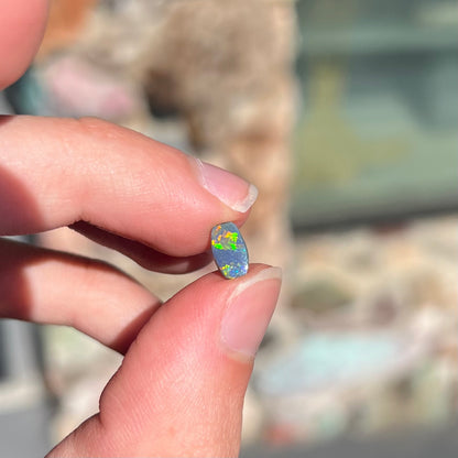 A loose, barrel shaped black opal stone from Lightning Ridge, Australia.