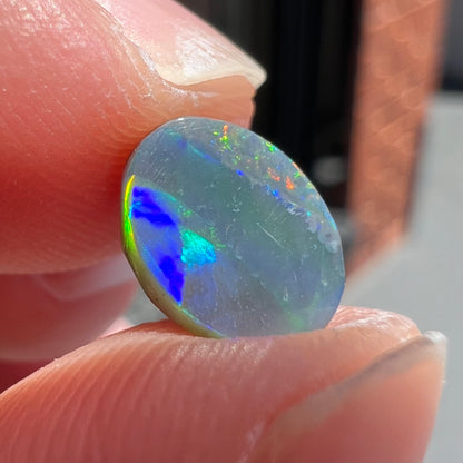 A loose, oval cut black opal from Lighting Ridge, Australia.  The stone is highly directional.