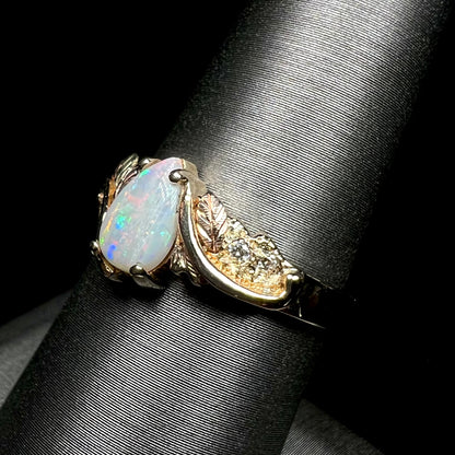 A ladies' two-tone yellow and rose Black Hills gold opal and diamond ring.  The opal is a pear shaped cabochon.