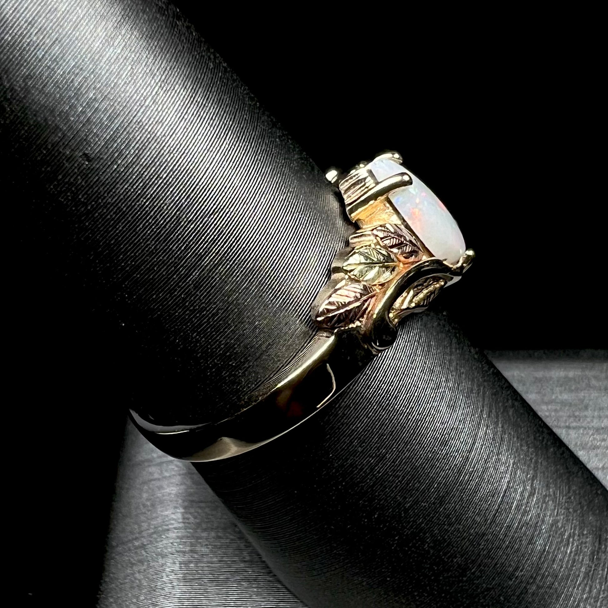 A ladies' two-tone yellow and rose Black Hills gold opal and diamond ring.  The opal is a pear shaped cabochon.