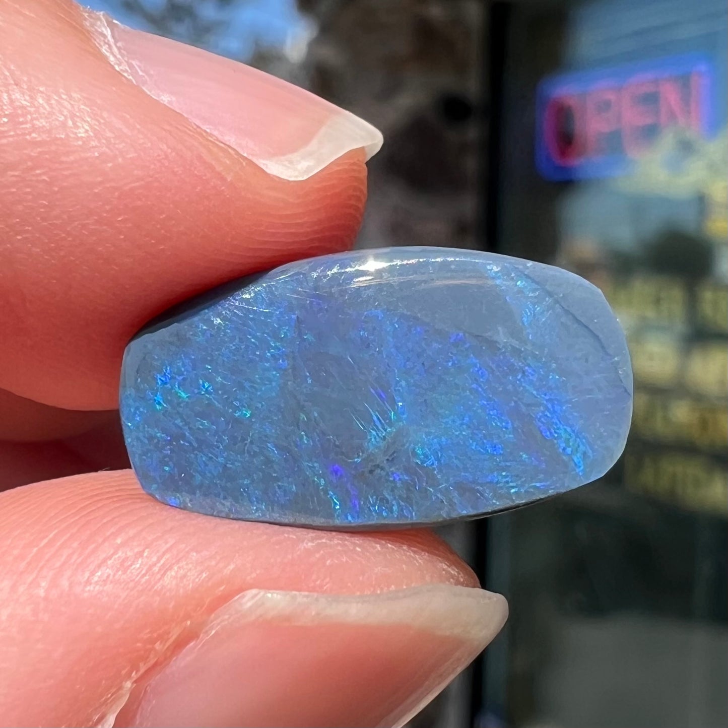 A loose, barrel shaped black opal stone from Lightning Ridge, Australia that weighs 5.25 carats.