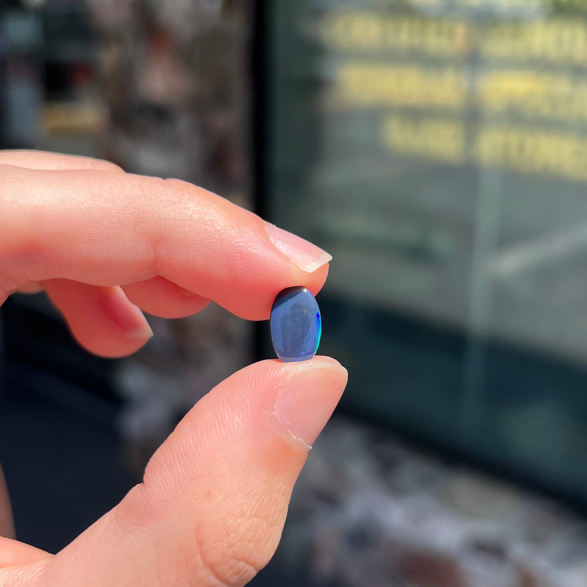 A loose, oval cabochon cut black opal from Lightning Ridge, Australia.  The opal has an N2 body tone.