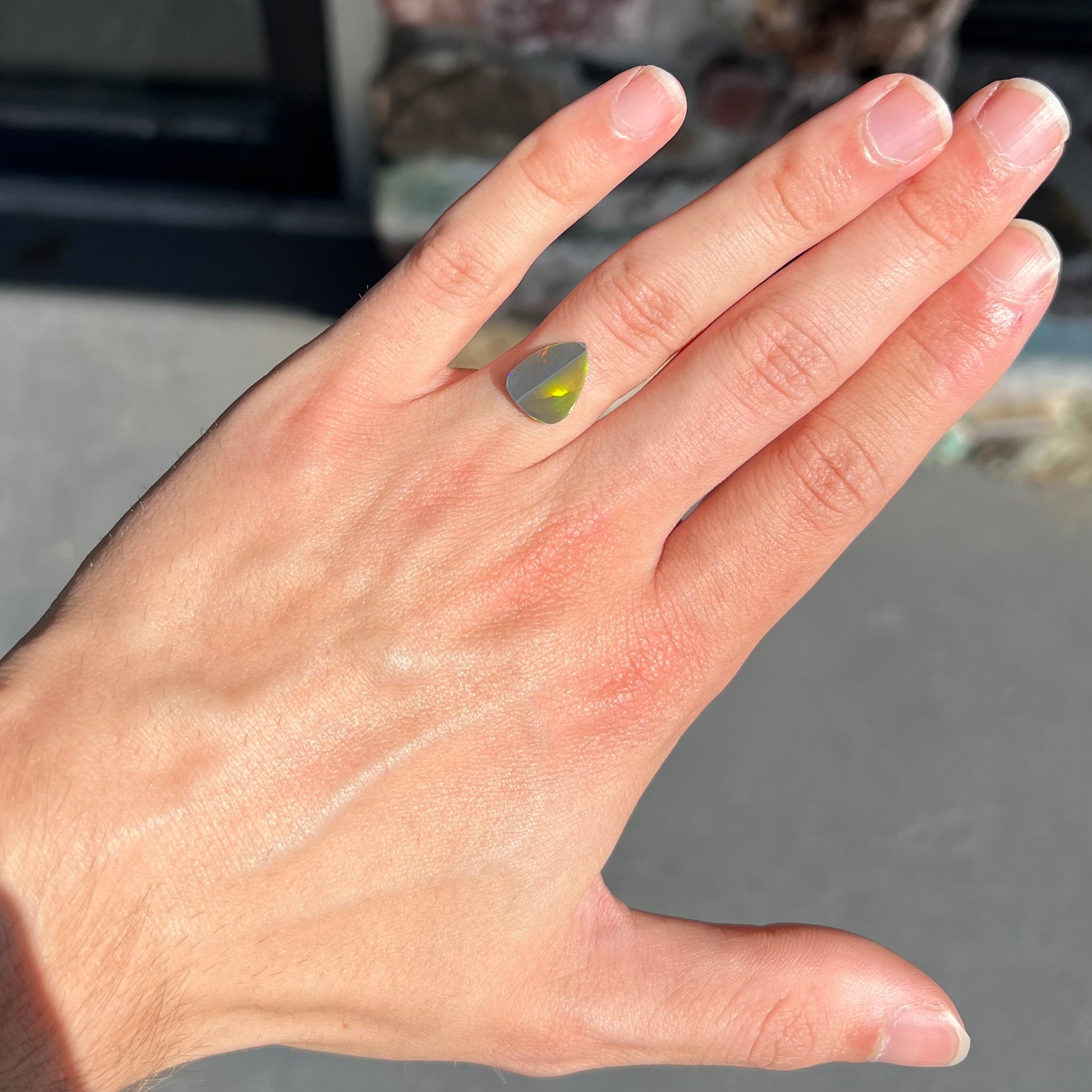 A loose, pear shaped black opal stone from Lightning Ridge, Austalia that weighs 1.19 carats.