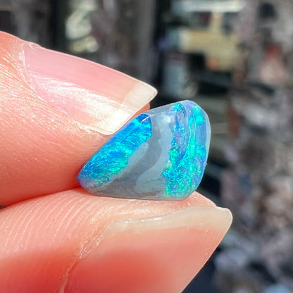 A 1.63 carat loose black opal stone from Lightning Ridge, Australia.  The opal is a freeform shape.