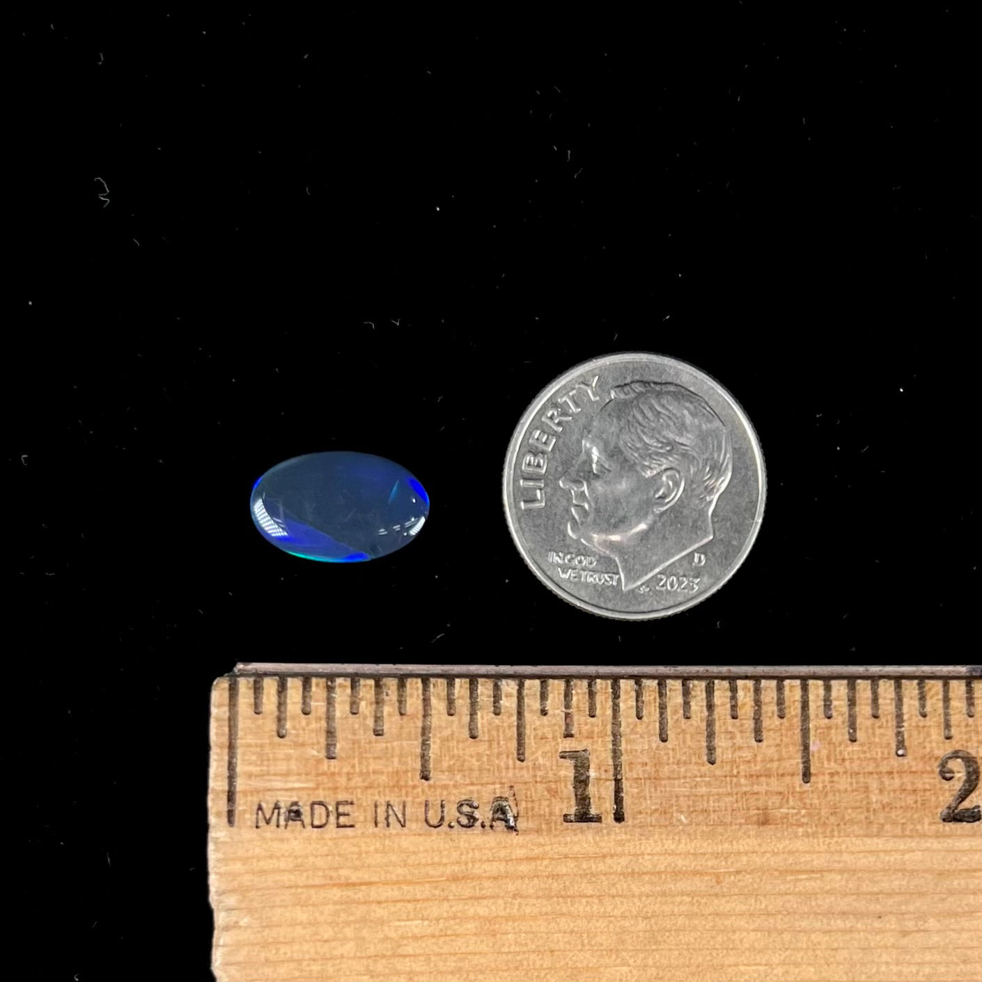 A loose, oval cabochon cut black opal from Lightning Ridge, Australia.  The opal has an N2 body tone.