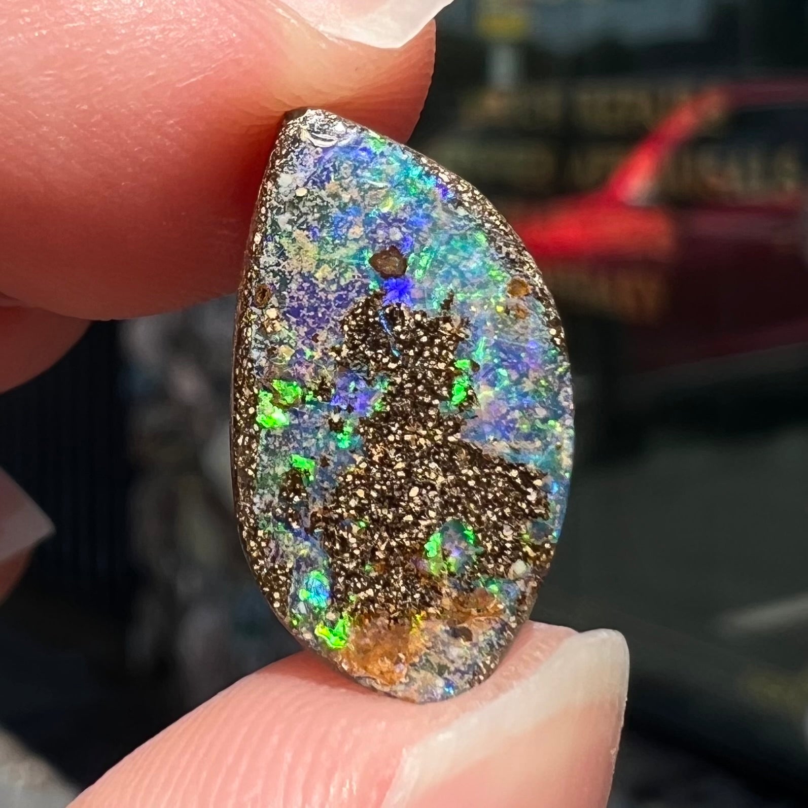 A loose boulder opal stone from Quilpie, Australia.  The opal has bright green and blue flashes.