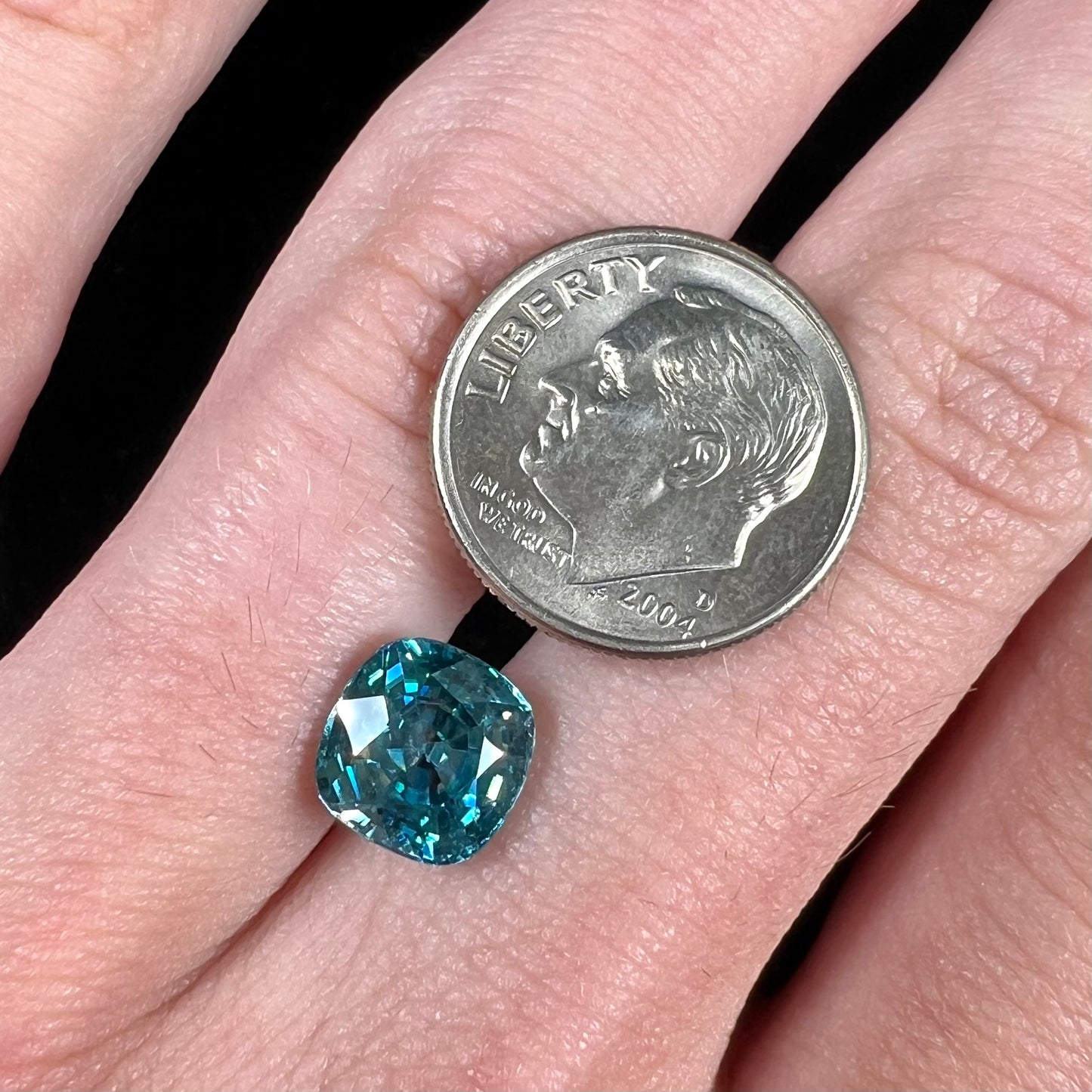 A loose cushion cut blue zircon stone.