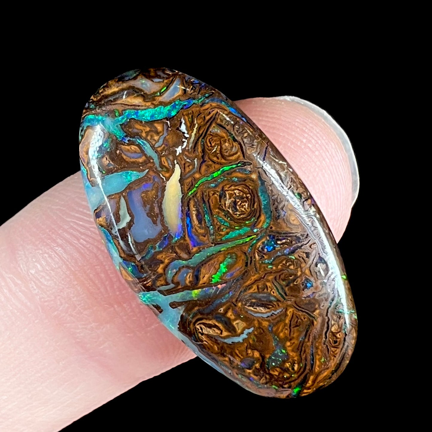 A loose, oval shaped Koroit boulder matrix opal.  The stone has patterns that resembles a rose.