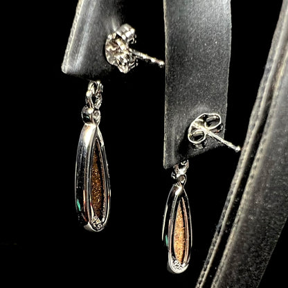 A pair of sterling silver dangle earrings mounted with pear shaped black opal doublets.