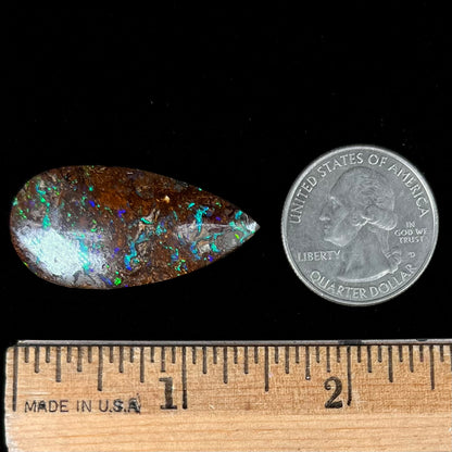 A pear shaped boulder opal stone from Koroit, Australia.  The opal has blue and green flashes.