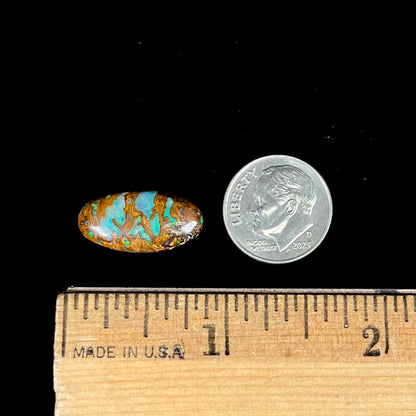 An oval cabochon cut boulder opal stone from Koroit, Australia.  The opal has a blue color.