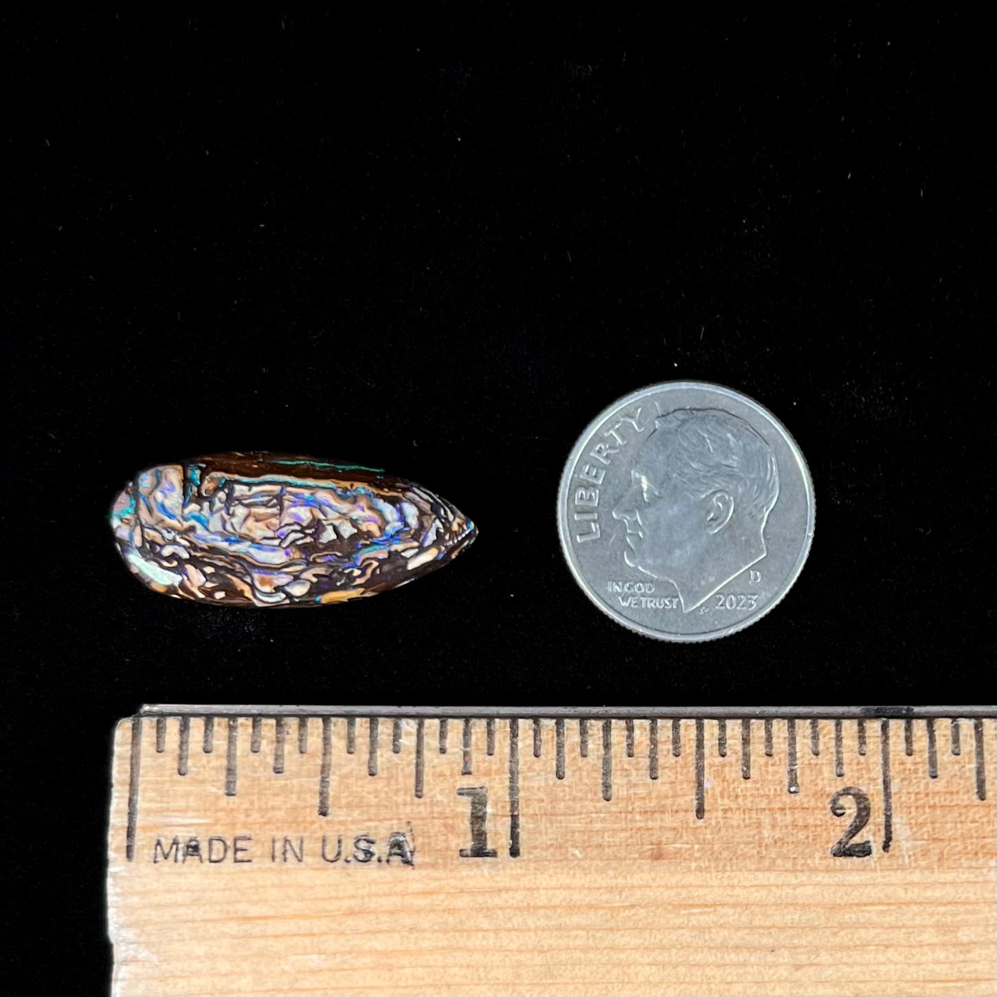 A pear shaped Koroit boulder matrix opal with blue and purple colors in veins.