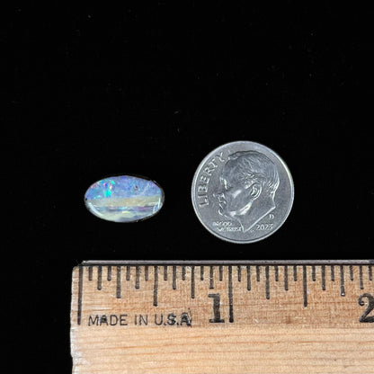 An oval cabochon cut boulder opal from Quilpie, Australia.  The opal has multicolor color play.