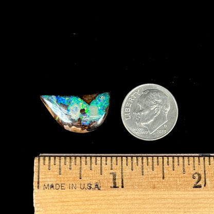 A loose, freeform shaped boulder opal with green and blue multicolor fire from Australia.