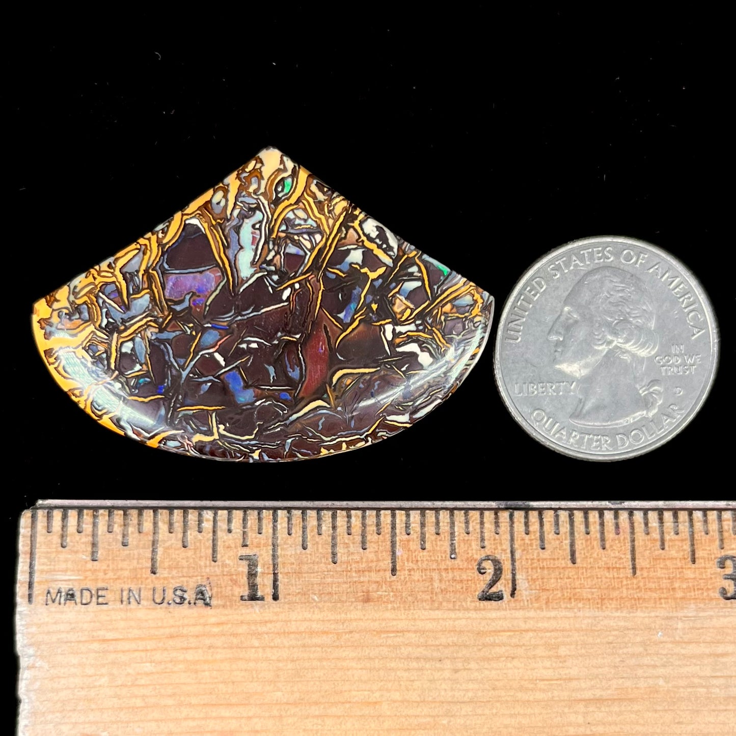 A loose, polished Koroit boulder opal specimen.  The opal has an organic pattern.