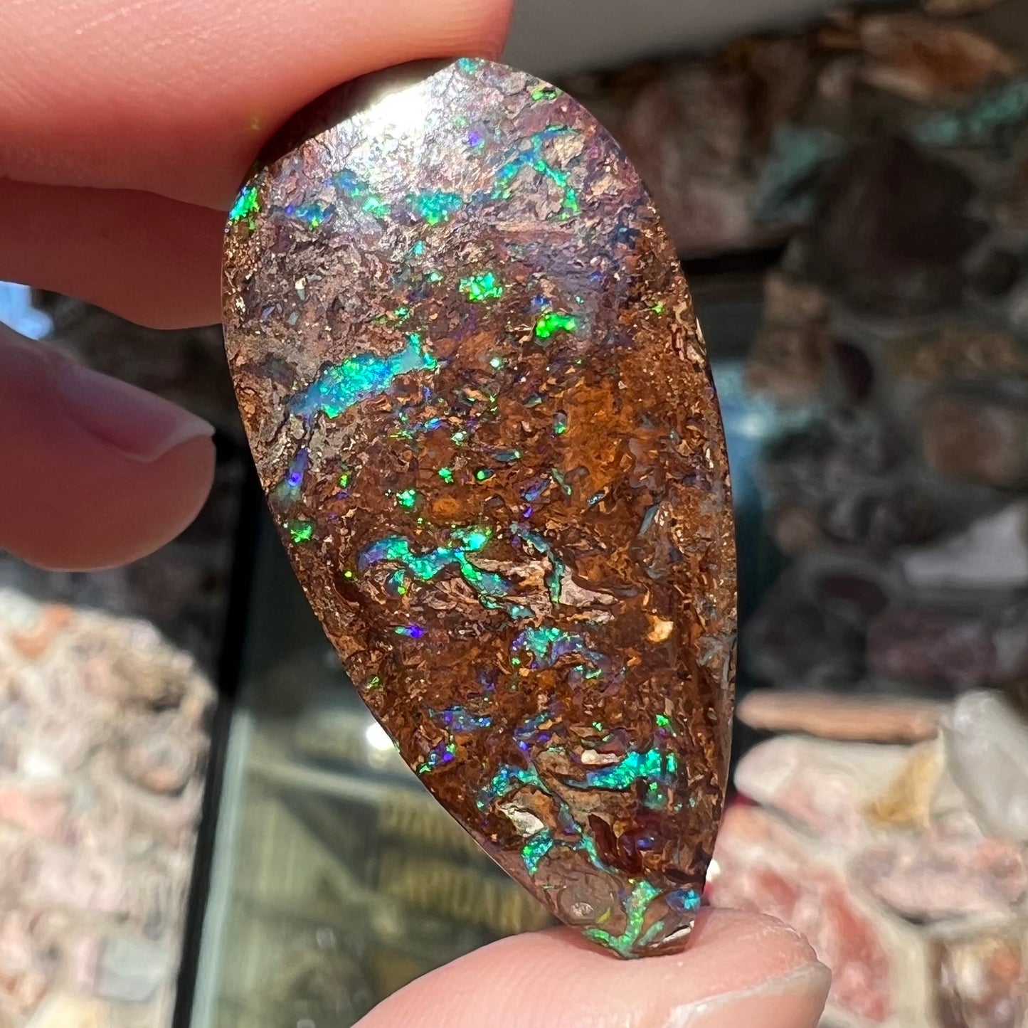 A pear shaped boulder opal stone from Koroit, Australia.  The opal has blue and green flashes.