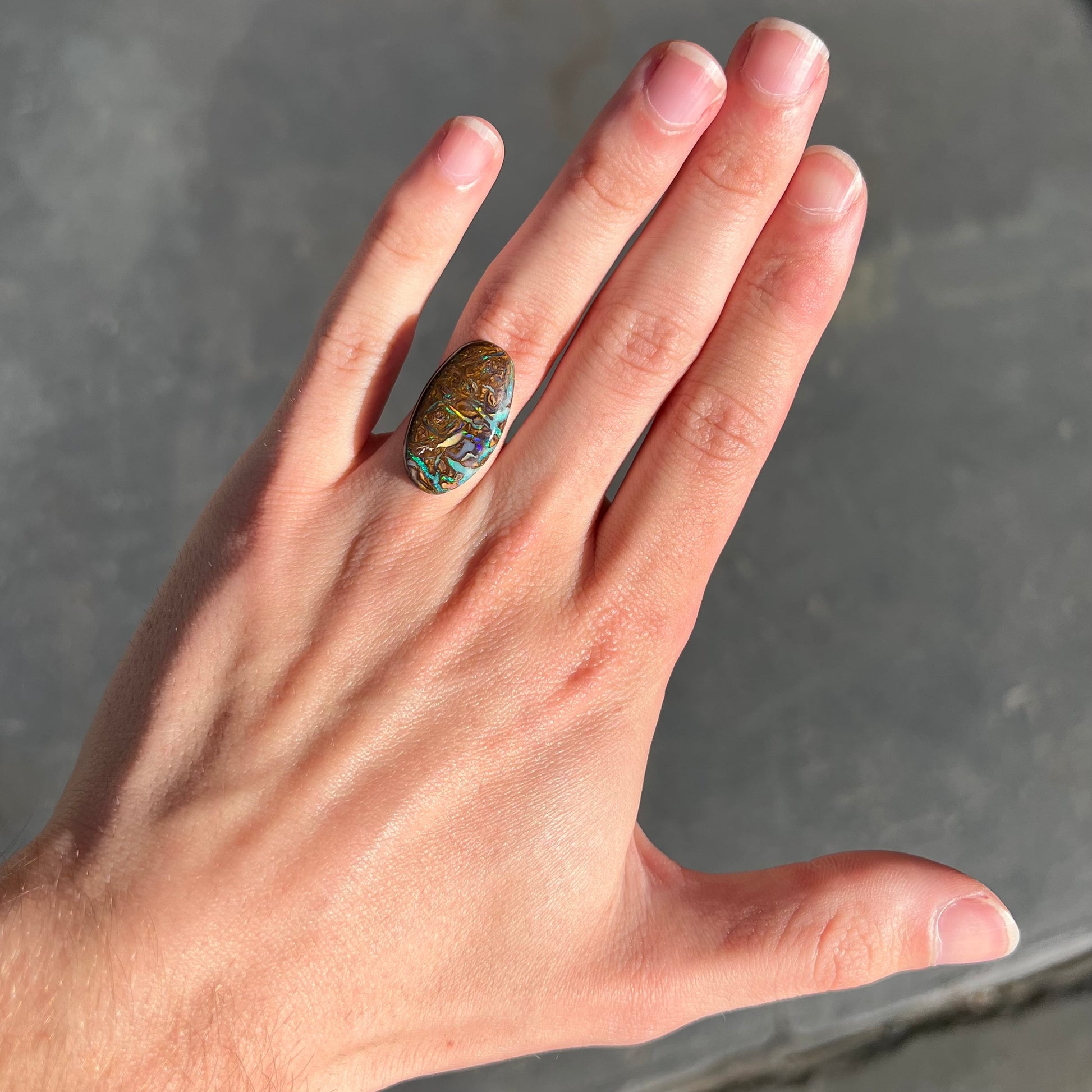 A loose, oval shaped Koroit boulder matrix opal.  The stone has patterns that resembles a rose.