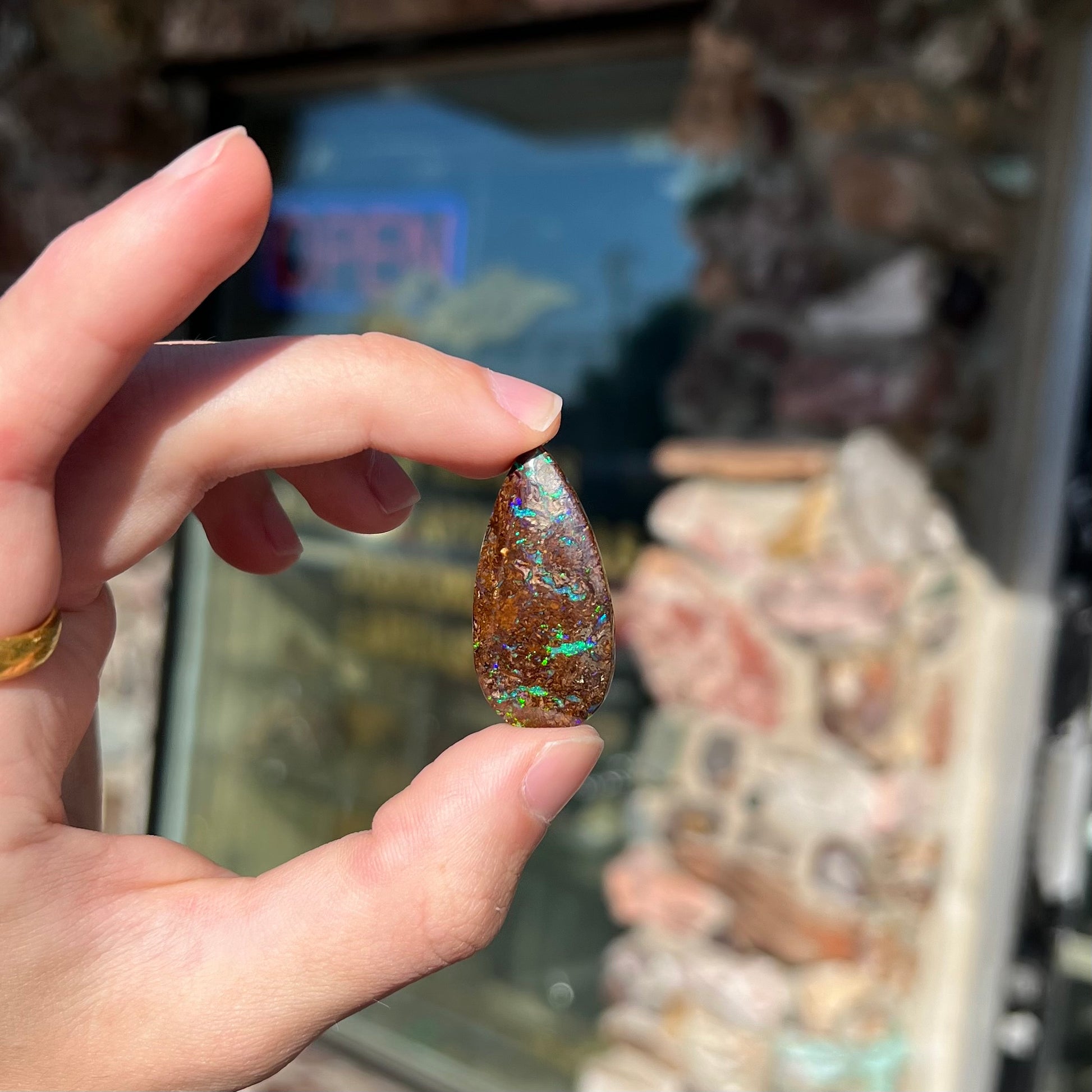 A pear shaped boulder opal stone from Koroit, Australia.  The opal has blue and green flashes.