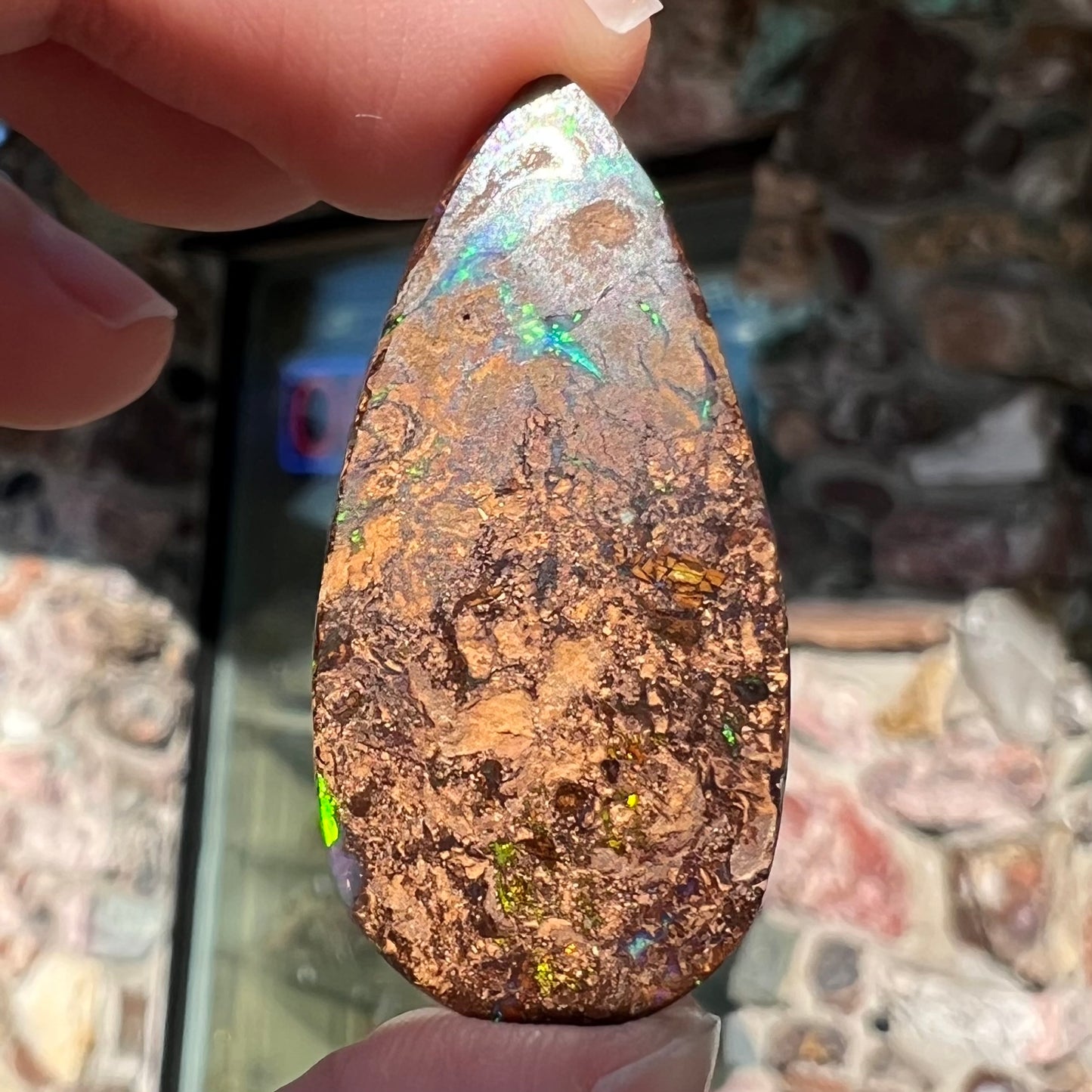 A pear shaped boulder opal stone from Koroit, Australia.  The opal has blue and green flashes.