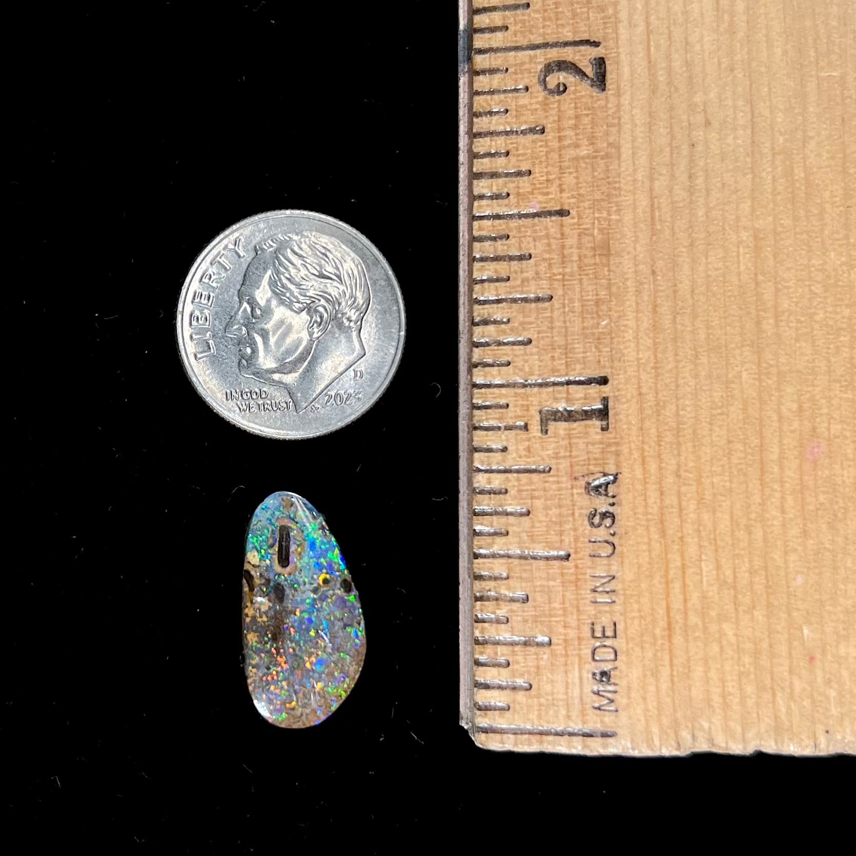 A loose boulder opal stone from Quilpie, Australia.  The opal shines colors of green and orange.