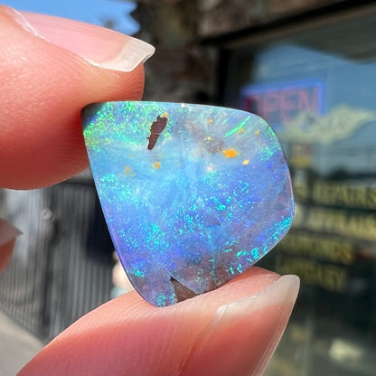 A loose, freeform shaped double-sided boulder opal stone from Quilpie, Australia.  One side is blue, the other is white.