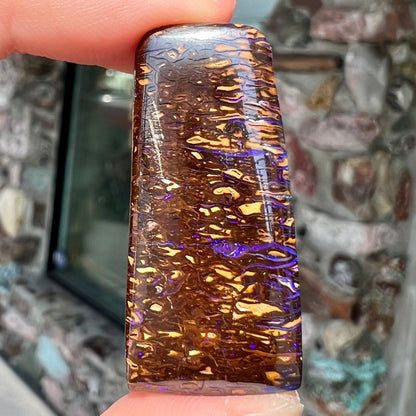 A loose boulder opal stone with purple veins from Koroit, Australia.