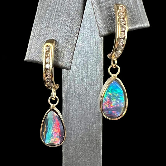 A pair of yellow gold dangle earrings set with natural pear shaped boulder opals and diamonds.