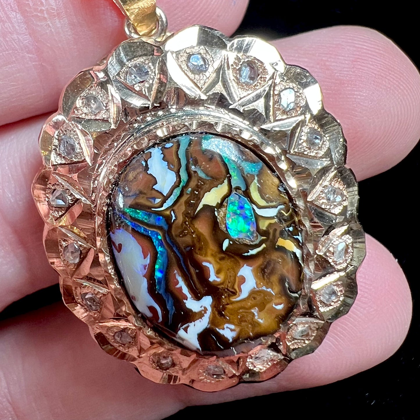 An antique 18 karat yellow gold pendant set with rough diamonds and an oval cut boulder opal from Koroit, Australia.