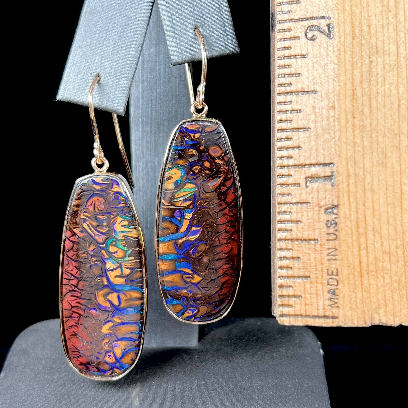 A matched pair of yellow gold patterned boulder opal dangle earrings.  The opals are from Koroit, Australia.