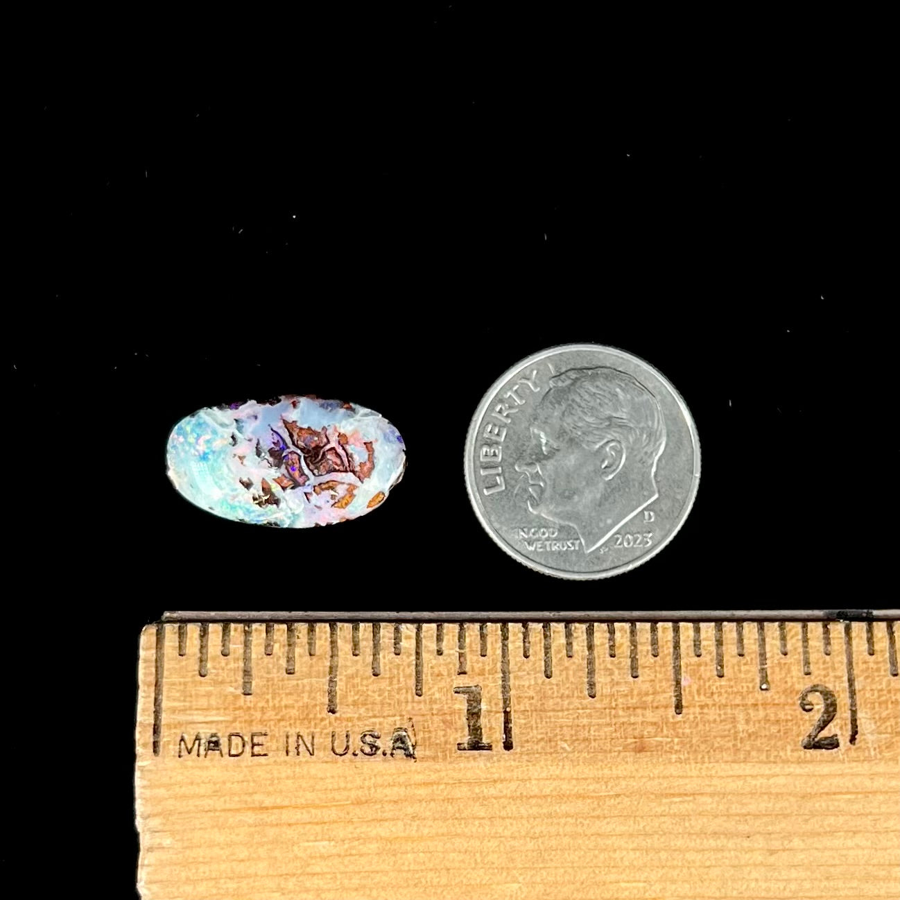 An oval cabochon cut boulder opal stone from Koroit, Australia.  The opal has a white body tone.