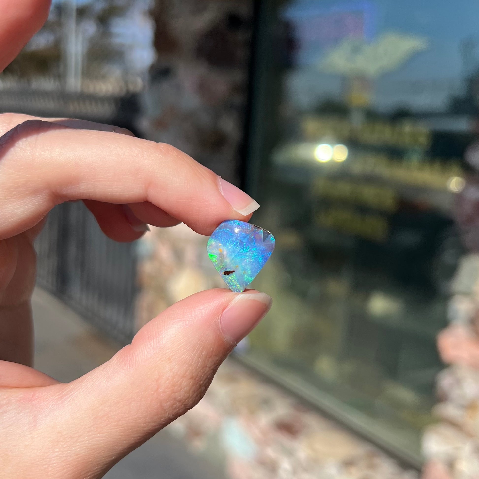 A loose, freeform shaped double-sided boulder opal stone from Quilpie, Australia.  One side is blue, the other is white.