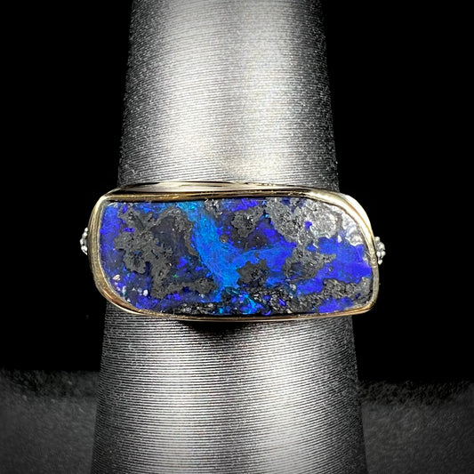 A two-tone sterling silver and 18k gold ring set with a blue boulder opal stone.  The shank is textured.