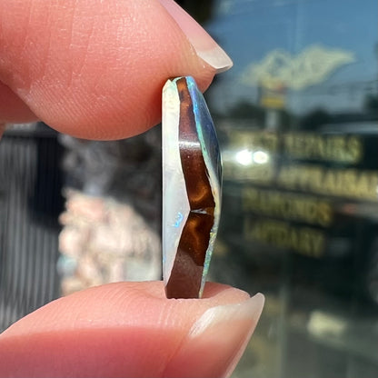 A loose, freeform shaped double-sided boulder opal stone from Quilpie, Australia.  One side is blue, the other is white.