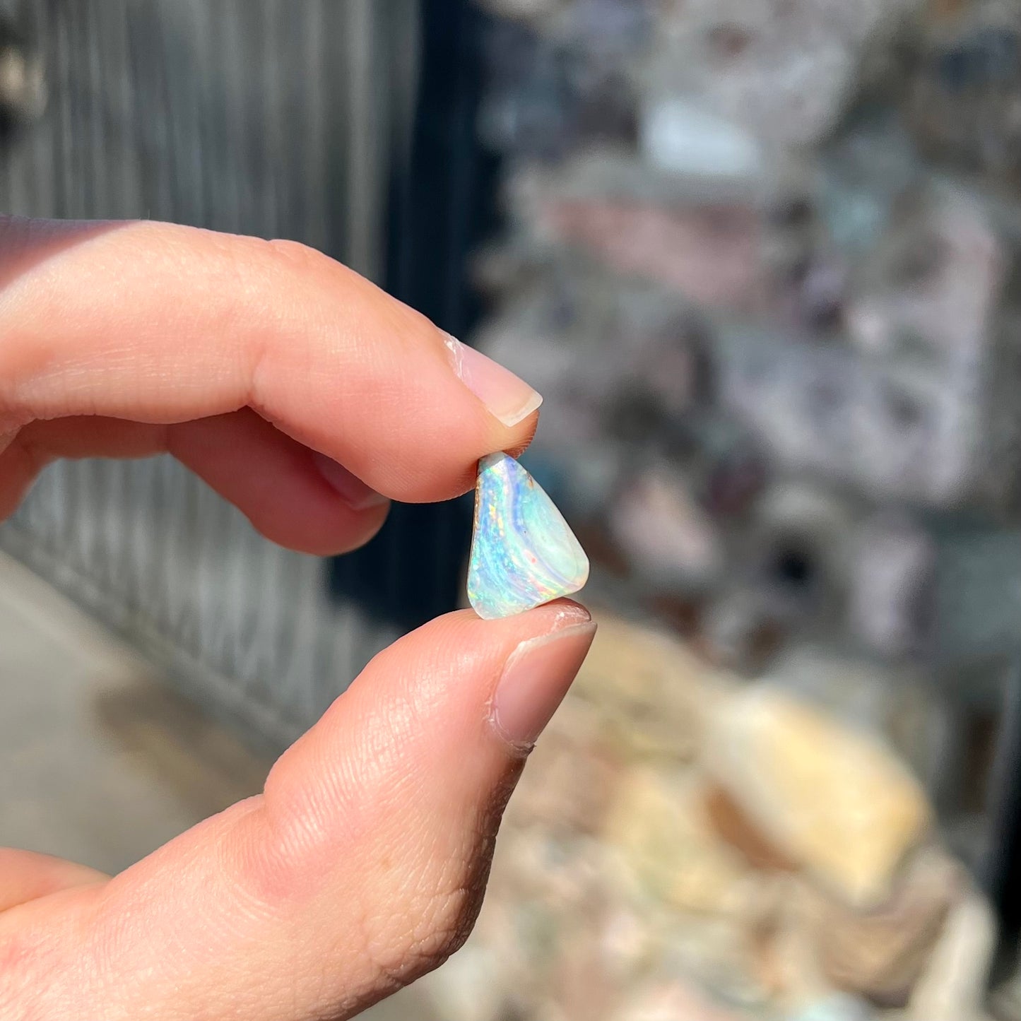 A loose, freeform boulder opal stone from Quilpie, Australia.  The opal has a fissure inclusion.