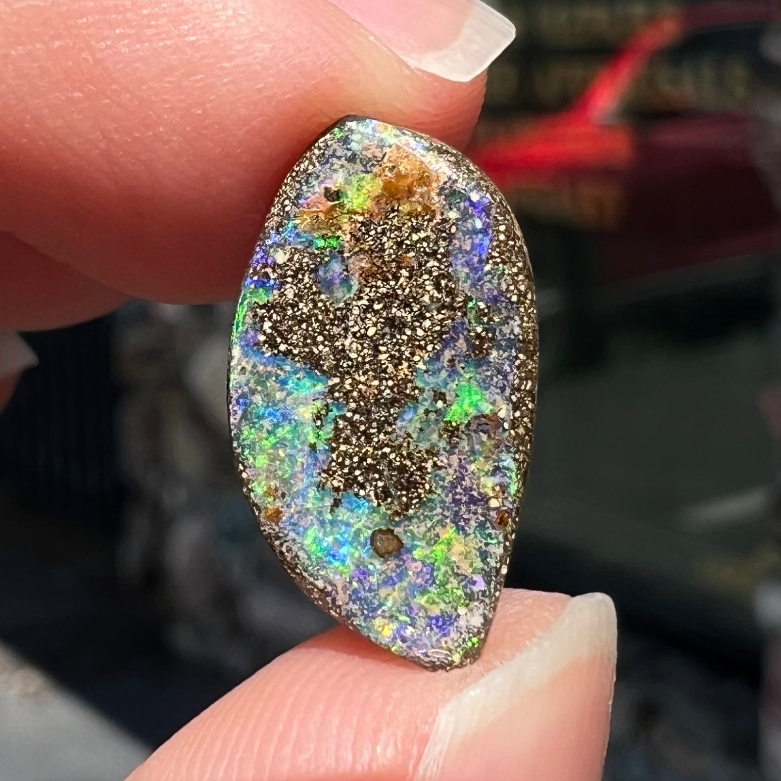 A loose boulder opal stone from Quilpie, Australia.  The opal has bright green and blue flashes.