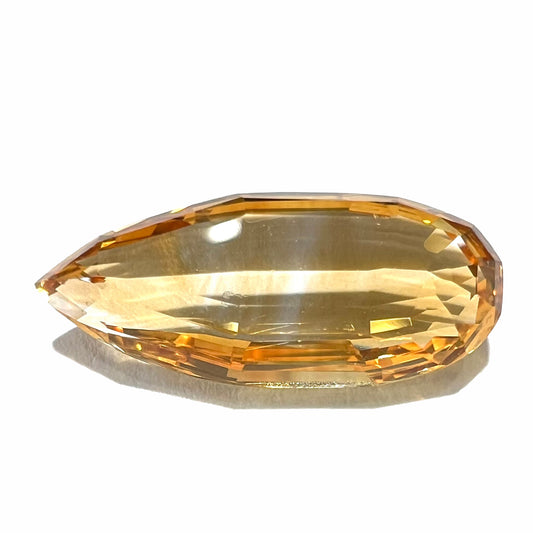 A loose, faceted briolette cut citrine gemstone.