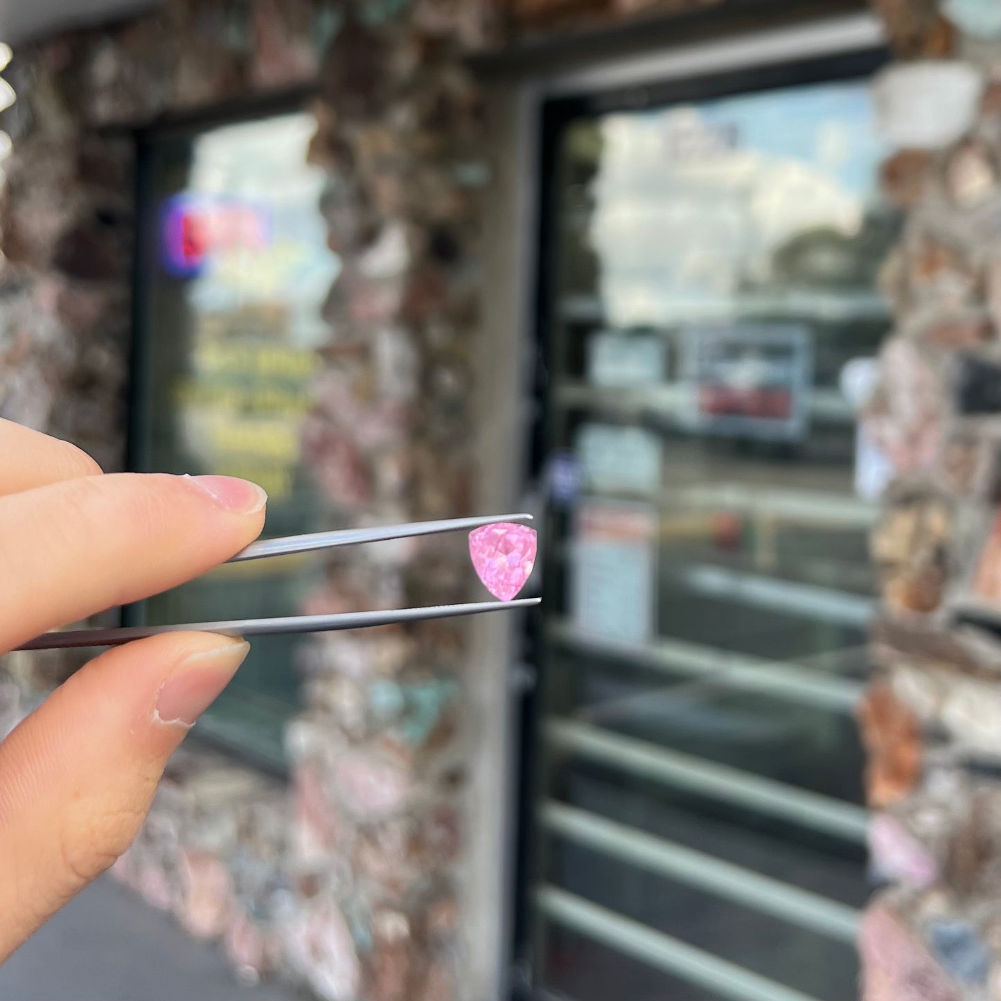 A loose, faceted trillion cut pink touramline gemstone.  The stone is a light bubblegum pink color.