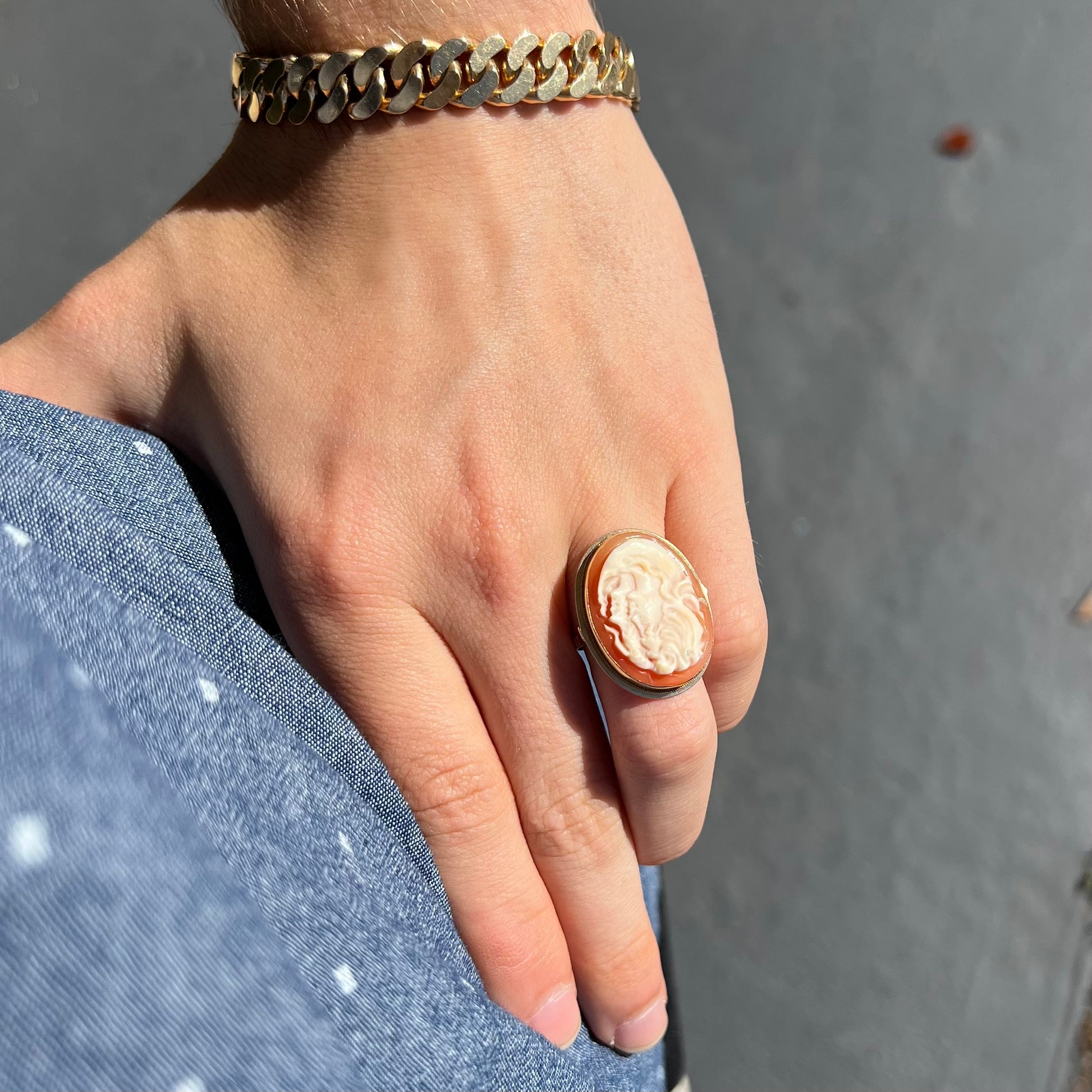 A ladies' vintage cameo solitaire ring in yellow gold.  The cameo is carved from shell and depicts the side profile of two womens' faces.