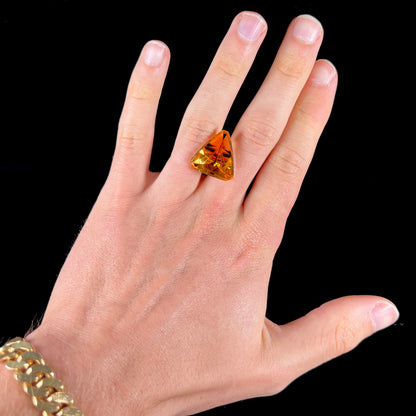 A loose, triangular fantasy cut yellow citrine stone cut by Arthur Lee Anderson.