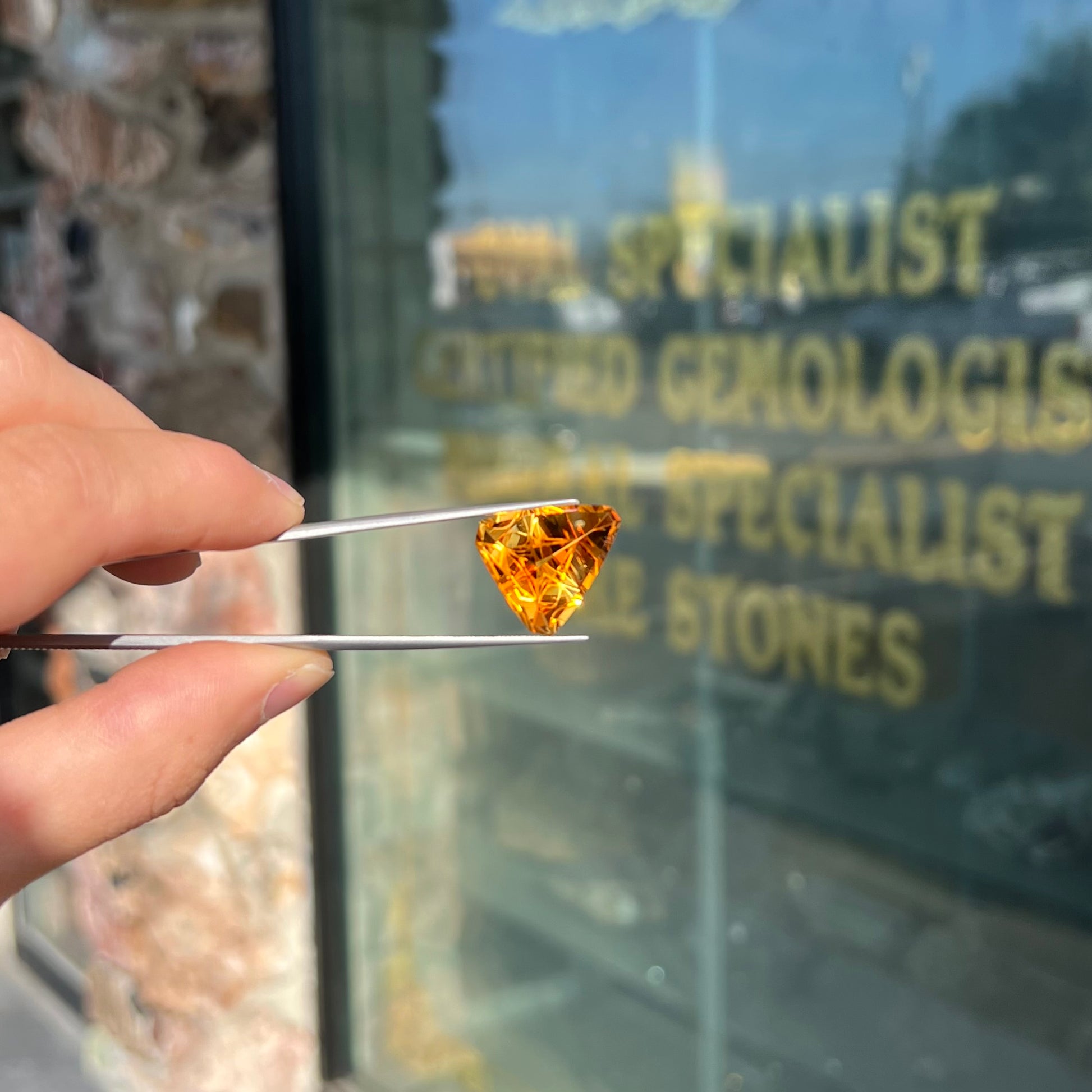 A loose, triangular fantasy cut yellow citrine stone cut by Arthur Lee Anderson.