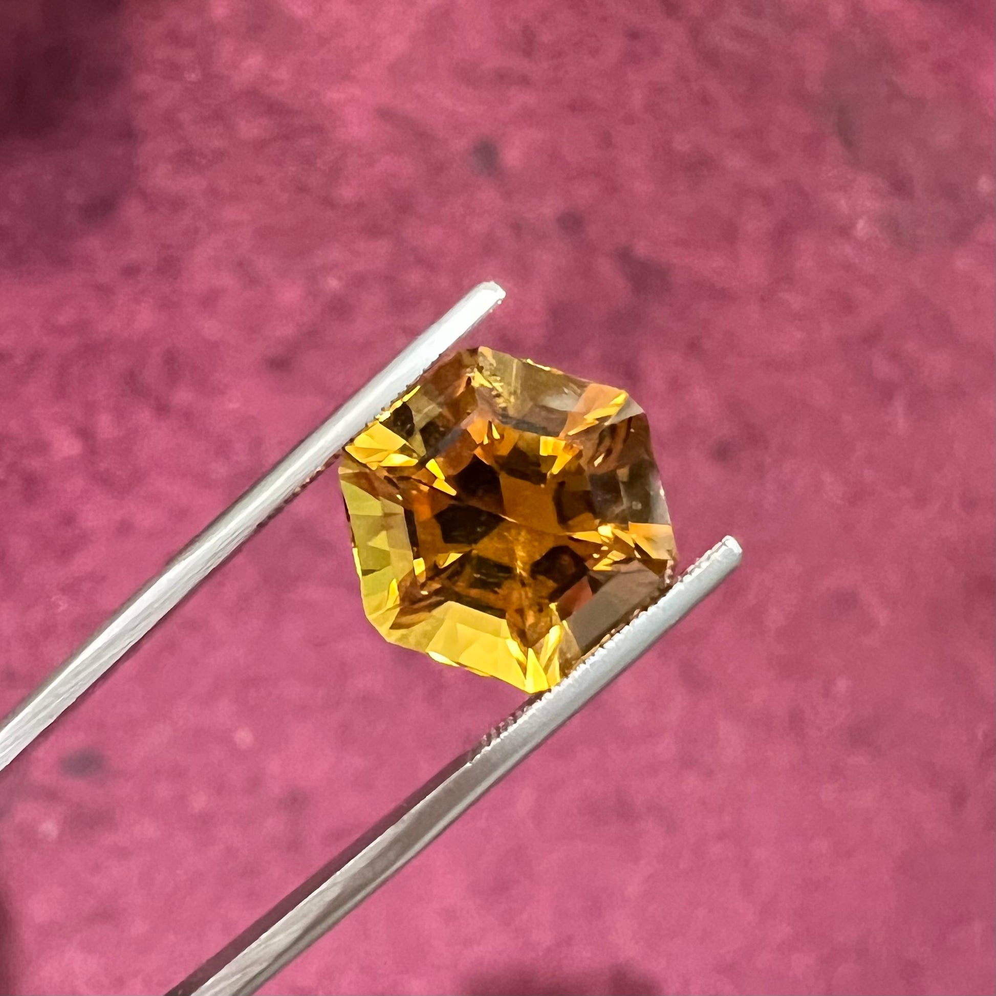 A loose, faceted hexagon cut citrine gem.  The stone is golden yellow color.