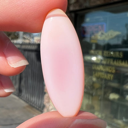 A loose, marquise cabochon cut pink common opal from Peru.  The opal has no play of color.